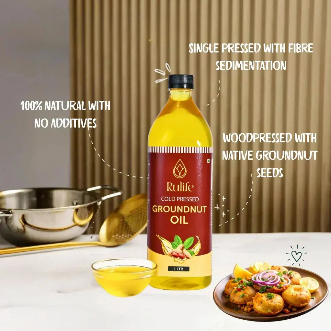 Close-up of a spoonful of oil showing the rich golden color and viscosity of unrefined, unfiltered groundnut oil