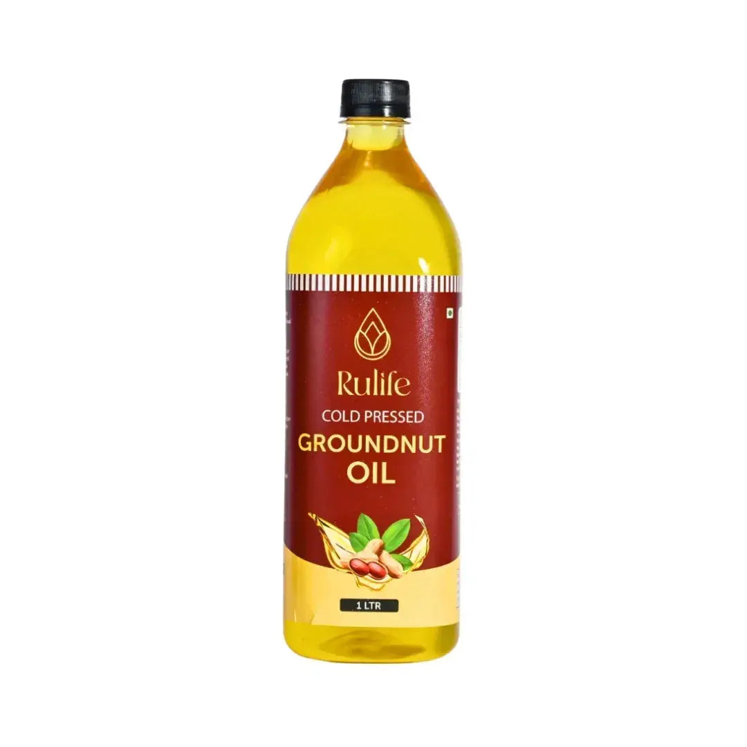 Bottle of pure wood pressed groundnut oil with raw peanuts in background.